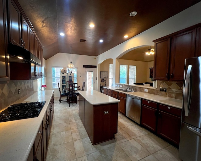 kitchen with stainless steel appliances, a sink, arched walkways, light countertops, and tasteful backsplash