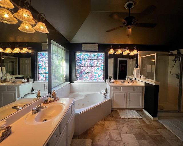 bathroom featuring a shower stall, a ceiling fan, stone tile flooring, a jetted tub, and two vanities