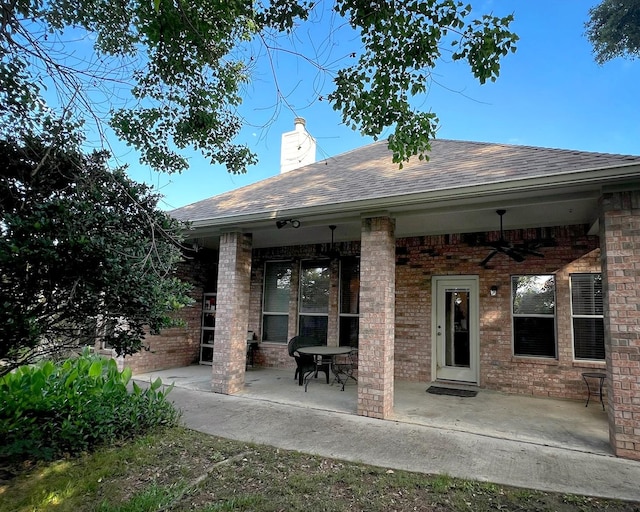 3002 Sandleigh Dr, Spring, TX 77388 - back of property with a ceiling fan, roof with shingles, a patio, brick siding, and a chimney
