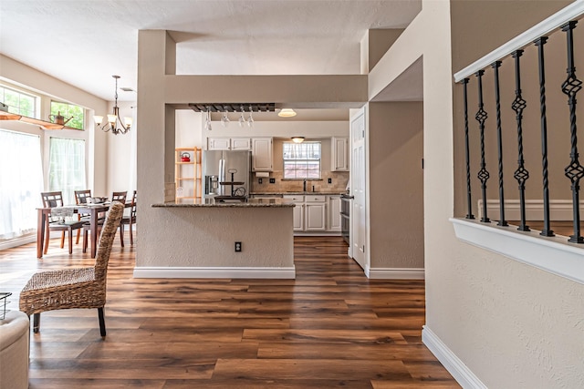 20423 Lone Star Oak St, Cypress, TX 77433 - kitchen featuring stainless steel fridge, a chandelier, a peninsula, dark wood-style floors, and baseboards