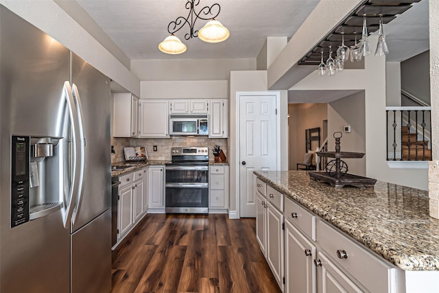 20423 Lone Star Oak St, Cypress, TX 77433 - kitchen with stainless steel appliances, light stone counters, dark wood-type flooring, tasteful backsplash, and a chandelier