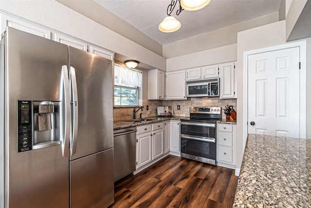 20423 Lone Star Oak St, Cypress, TX 77433 - kitchen featuring stainless steel appliances, a sink, dark wood finished floors, dark stone counters, and decorative backsplash