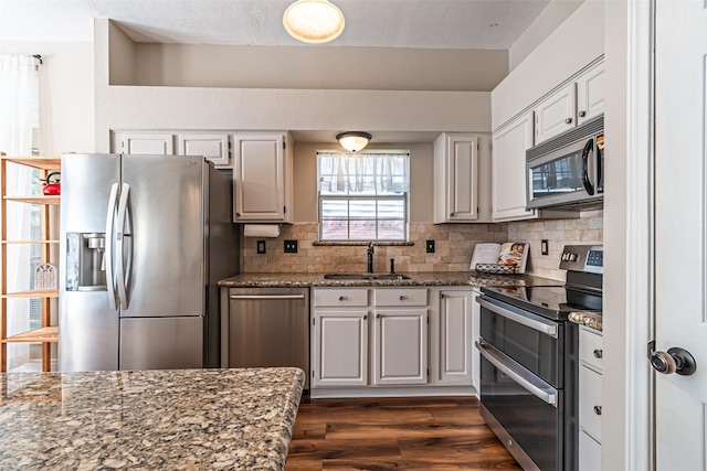 20423 Lone Star Oak St, Cypress, TX 77433 - kitchen with appliances with stainless steel finishes, a sink, dark wood finished floors, backsplash, and dark stone counters