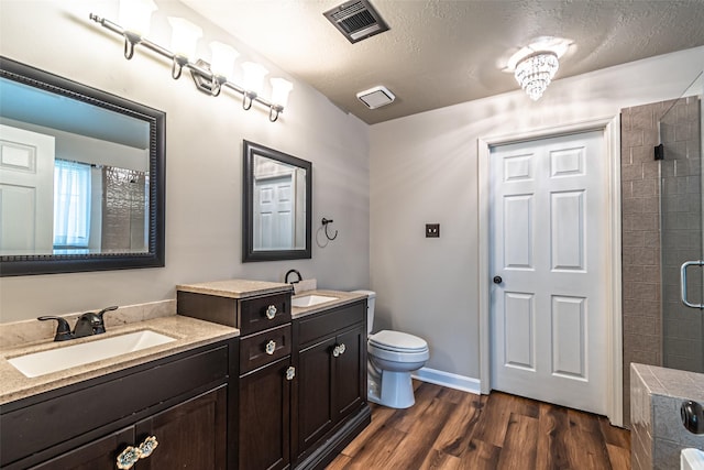 20423 Lone Star Oak St, Cypress, TX 77433 - bathroom featuring wood finished floors, a shower, toilet, double vanity, and a textured ceiling