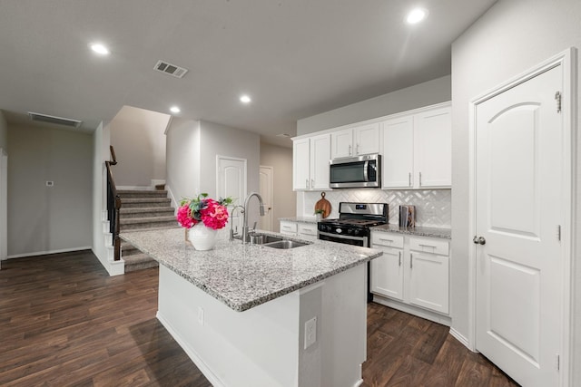 4438 Andorno Dr, Katy, TX 77449 - kitchen featuring stainless steel appliances, a sink, a center island with sink, dark wood-style flooring, and tasteful backsplash