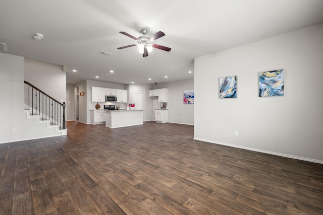 4438 Andorno Dr, Katy, TX 77449 - unfurnished living room with dark wood-type flooring, a ceiling fan, baseboards, stairs, and recessed lighting