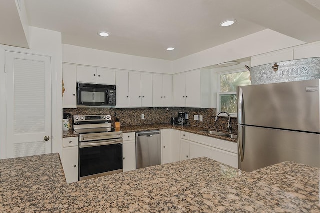 4242 Pelican Ln, Galveston, TX 77554 - kitchen with appliances with stainless steel finishes, a sink, white cabinets, dark stone counters, and backsplash