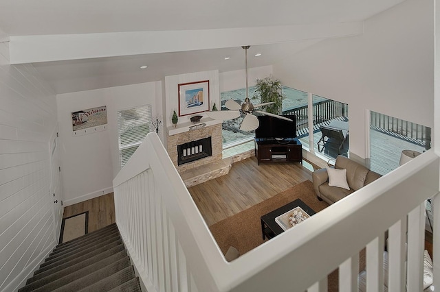 4242 Pelican Ln, Galveston, TX 77554 - staircase featuring wood finished floors, ceiling fan, a stone fireplace, baseboards, and lofted ceiling