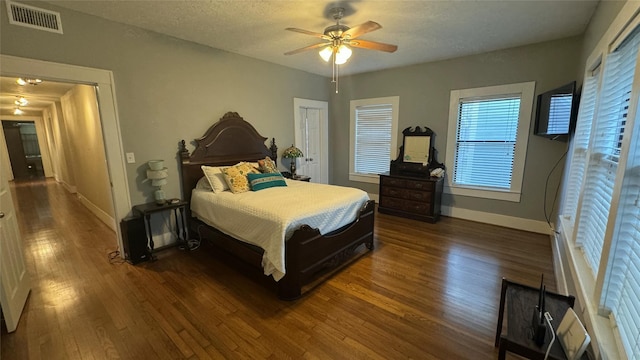 bedroom featuring wood finished floors, baseboards, and a ceiling fan