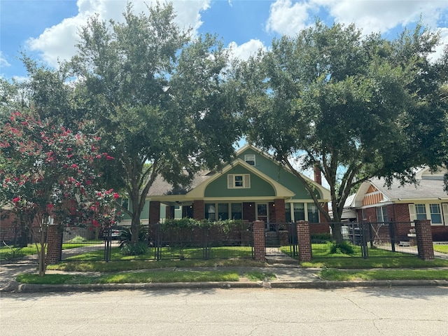 view of front of property with a fenced front yard, brick siding, and a gate