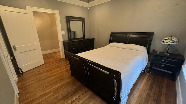 bedroom featuring crown molding, wood finished floors, and baseboards