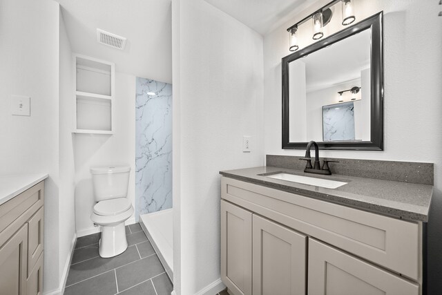 bathroom with a marble finish shower, vanity, and toilet