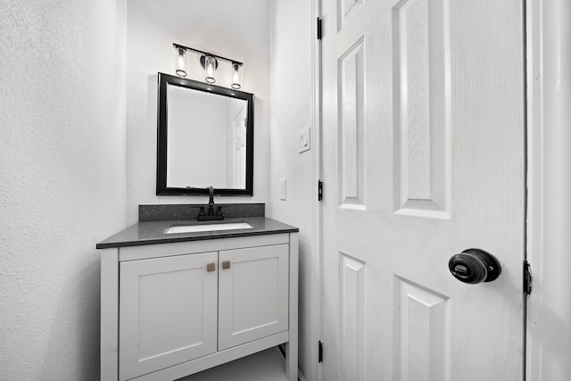 bathroom featuring vanity and a textured wall