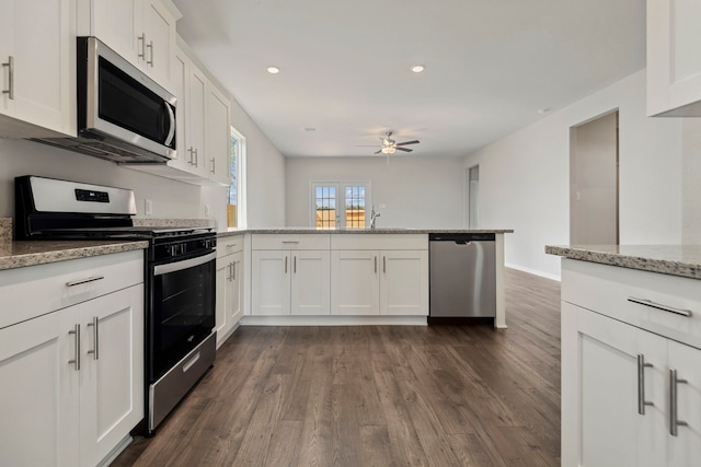 16449 Blossom Grove Dr, Conroe, TX 77303 - kitchen with appliances with stainless steel finishes, a peninsula, a ceiling fan, dark wood-style floors, and white cabinetry