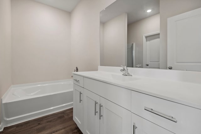 16449 Blossom Grove Dr, Conroe, TX 77303 - bathroom with wood finished floors, vanity, a garden tub, and recessed lighting