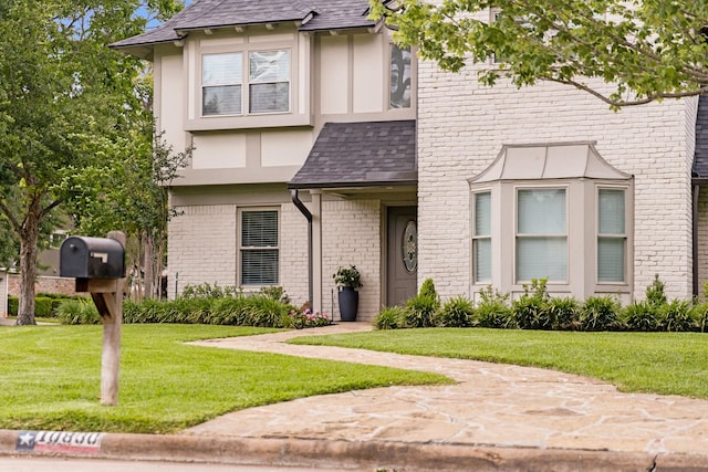 10830 Piping Rock Ln, Houston, TX 77042 - view of front of house featuring a front yard, brick siding, roof with shingles, and stucco siding