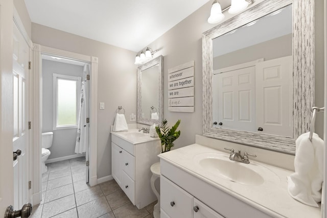 10830 Piping Rock Ln, Houston, TX 77042 - full bathroom with two vanities, toilet, tile patterned flooring, and baseboards