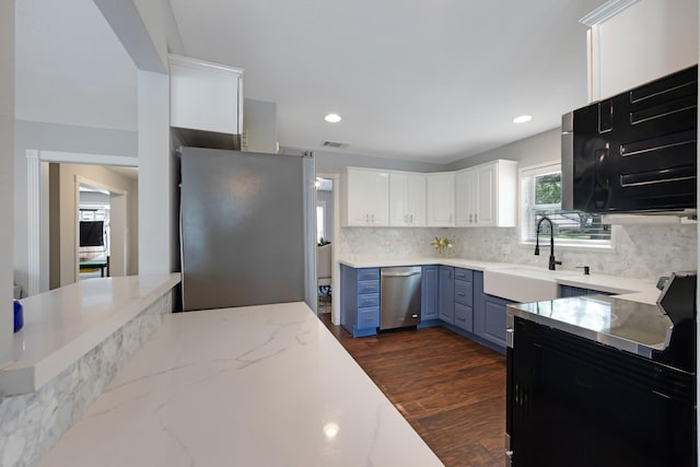10830 Piping Rock Ln, Houston, TX 77042 - kitchen featuring a sink, appliances with stainless steel finishes, dark wood-type flooring, decorative backsplash, and white cabinets
