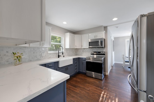 10830 Piping Rock Ln, Houston, TX 77042 - kitchen featuring stainless steel appliances, a sink, light stone counters, white cabinets, and dark wood-style floors