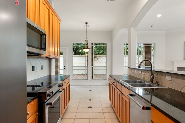 7615 Brae Acres Ct, Houston, TX 77074 - kitchen featuring appliances with stainless steel finishes, a sink, arched walkways, backsplash, and light tile patterned floors