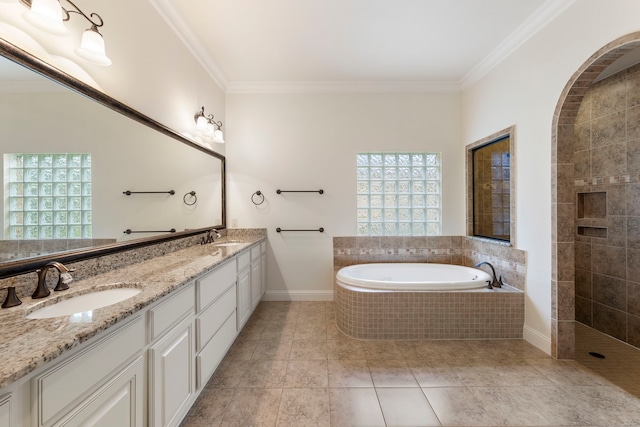 bathroom with healthy amount of natural light, crown molding, a garden tub, double vanity, and tile patterned flooring