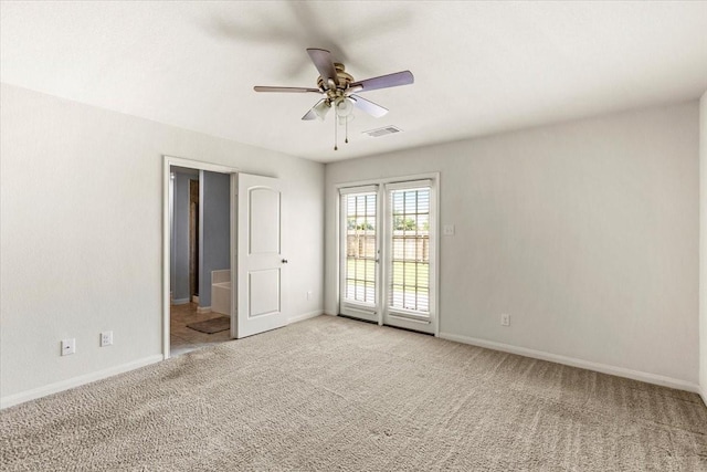 unfurnished bedroom featuring light colored carpet, baseboards, access to exterior, and ensuite bathroom