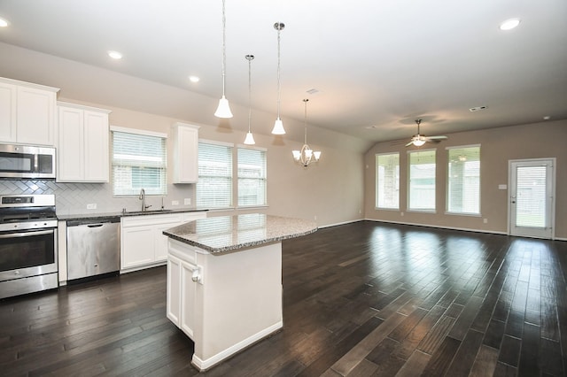 7718 Collina Landing Trl, Richmond, TX 77407 - kitchen with appliances with stainless steel finishes, a sink, ceiling fan, dark wood-style floors, and a kitchen island