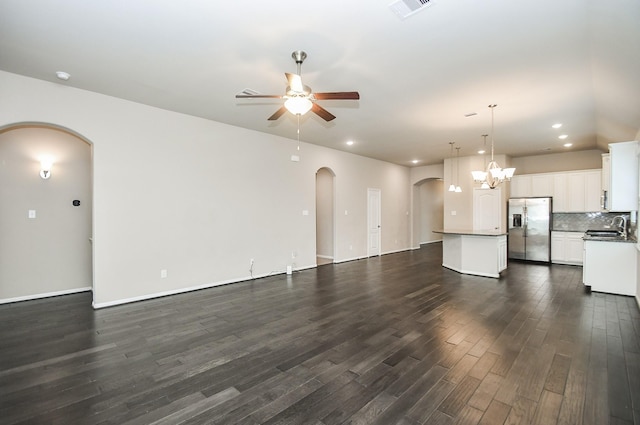 7718 Collina Landing Trl, Richmond, TX 77407 - unfurnished living room featuring arched walkways, a sink, a ceiling fan, dark wood-type flooring, and recessed lighting
