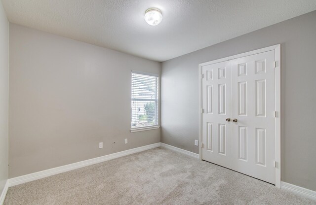 19835 Byron Meadows Dr, Katy, TX 77449 - unfurnished bedroom with carpet flooring, a closet, baseboards, and a textured ceiling