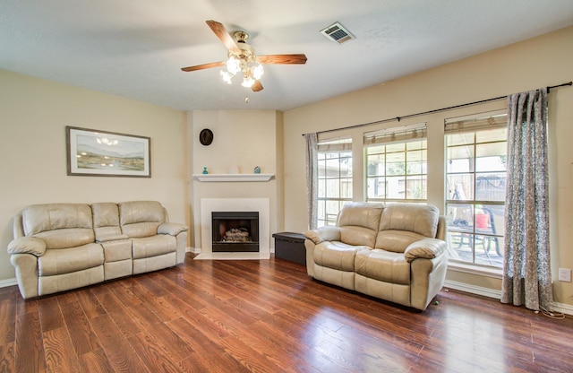 living room with a ceiling fan, dark wood finished floors, and healthy amount of natural light