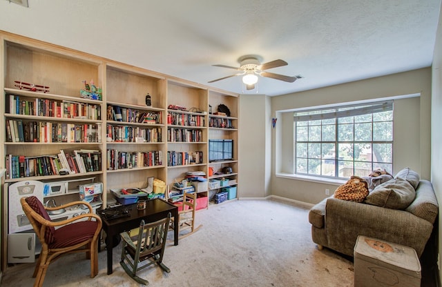 living area with ceiling fan, carpet, and baseboards