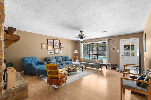 1001 Windy Dr, Brenham, TX 77833 - living area with light wood-type flooring, ceiling fan, a textured ceiling, and baseboards