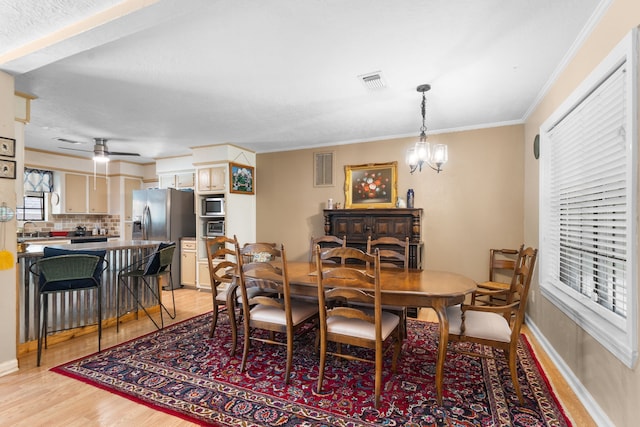 1001 Windy Dr, Brenham, TX 77833 - dining room featuring light wood-style floors, ornamental molding, ceiling fan, baseboards, and a chandelier