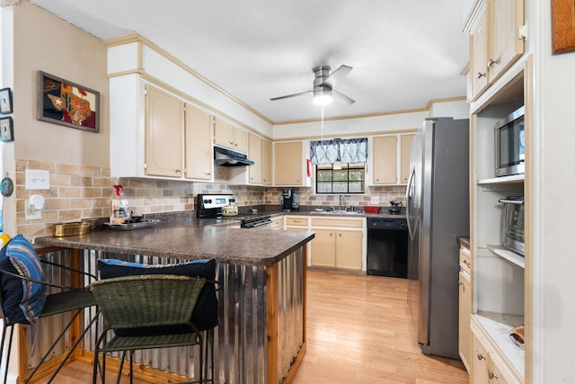 1001 Windy Dr, Brenham, TX 77833 - kitchen featuring stainless steel appliances, under cabinet range hood, a peninsula, a sink, and light wood finished floors