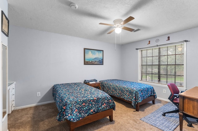 bedroom with a textured ceiling, carpet flooring, baseboards, and a ceiling fan