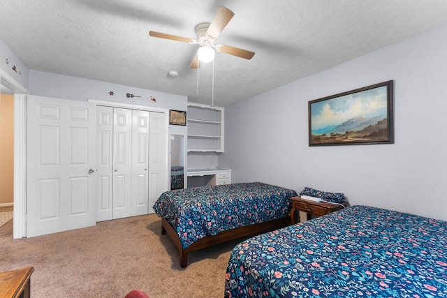 carpeted bedroom featuring a textured ceiling, a closet, and a ceiling fan