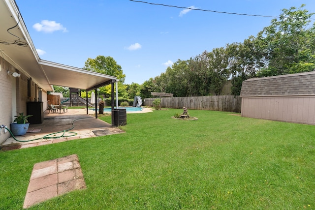 view of yard with a shed, a patio area, and an outbuilding