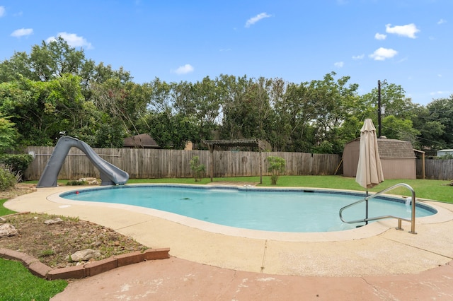 1001 Windy Dr, Brenham, TX 77833 - view of swimming pool featuring a water slide, view of wooded area, and a patio area