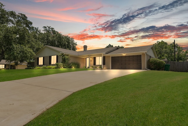 view of front facade with driveway, an attached garage, and a chimney