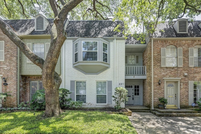 491 N Post Oak Ln Unit 491, Houston, TX 77024 - view of front of house featuring brick siding, a balcony, and roof with shingles