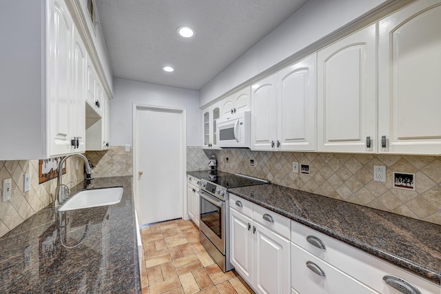 491 N Post Oak Ln Unit 491, Houston, TX 77024 - kitchen with stainless steel electric range oven, a sink, white microwave, dark stone countertops, and white cabinets