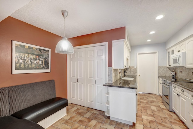491 N Post Oak Ln Unit 491, Houston, TX 77024 - kitchen with electric stove, white microwave, white cabinetry, backsplash, and a sink