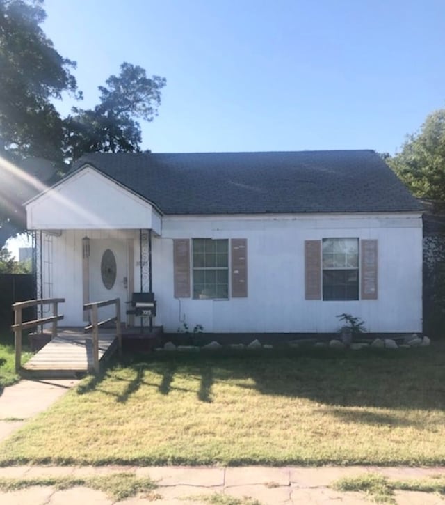 3025 Texas St, Vernon, TX 76384 - view of front of house with covered porch, roof with shingles, and a front yard