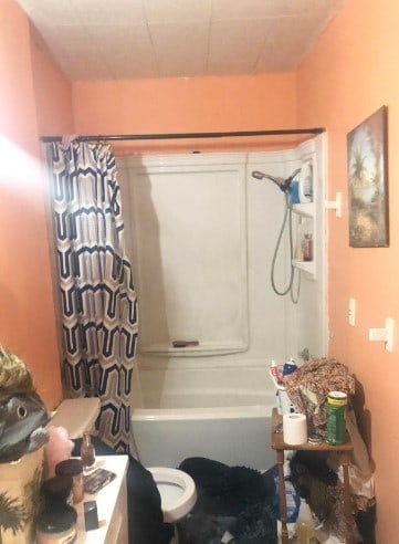 3025 Texas St, Vernon, TX 76384 - bathroom featuring shower / bathtub combination with curtain and toilet