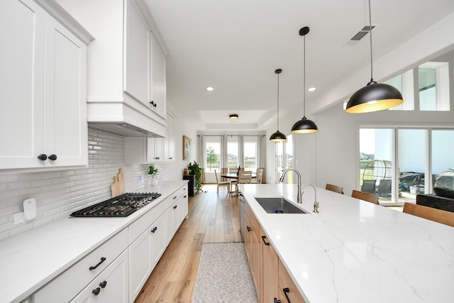 4914 Olive Province Ln, Manvel, TX 77578 - kitchen featuring stainless steel gas stovetop, a sink, decorative backsplash, light stone countertops, and recessed lighting