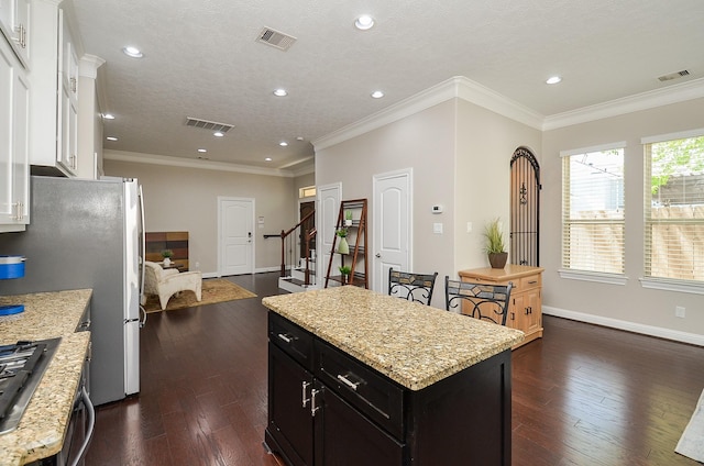 1913 Rosewood St, Houston, TX 77004 - kitchen featuring a kitchen island, stainless steel appliances, dark wood-type flooring, white cabinets, and light stone countertops