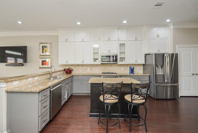 1913 Rosewood St, Houston, TX 77004 - kitchen featuring stainless steel appliances, a sink, a peninsula, ornamental molding, and light stone countertops