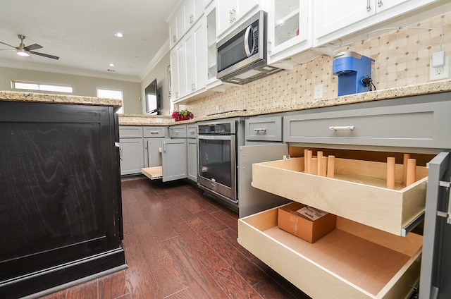 1913 Rosewood St, Houston, TX 77004 - kitchen featuring stainless steel appliances, crown molding, a ceiling fan, dark wood finished floors, and backsplash