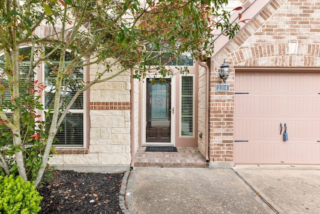 2314 Laurel Loch Ln, Pearland, TX 77584 - entrance to property featuring an attached garage, brick siding, stone siding, and driveway