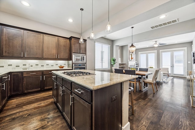 783 Waverly St, Houston, TX 77007 - kitchen with appliances with stainless steel finishes, dark wood-style flooring, plenty of natural light, a kitchen breakfast bar, and recessed lighting